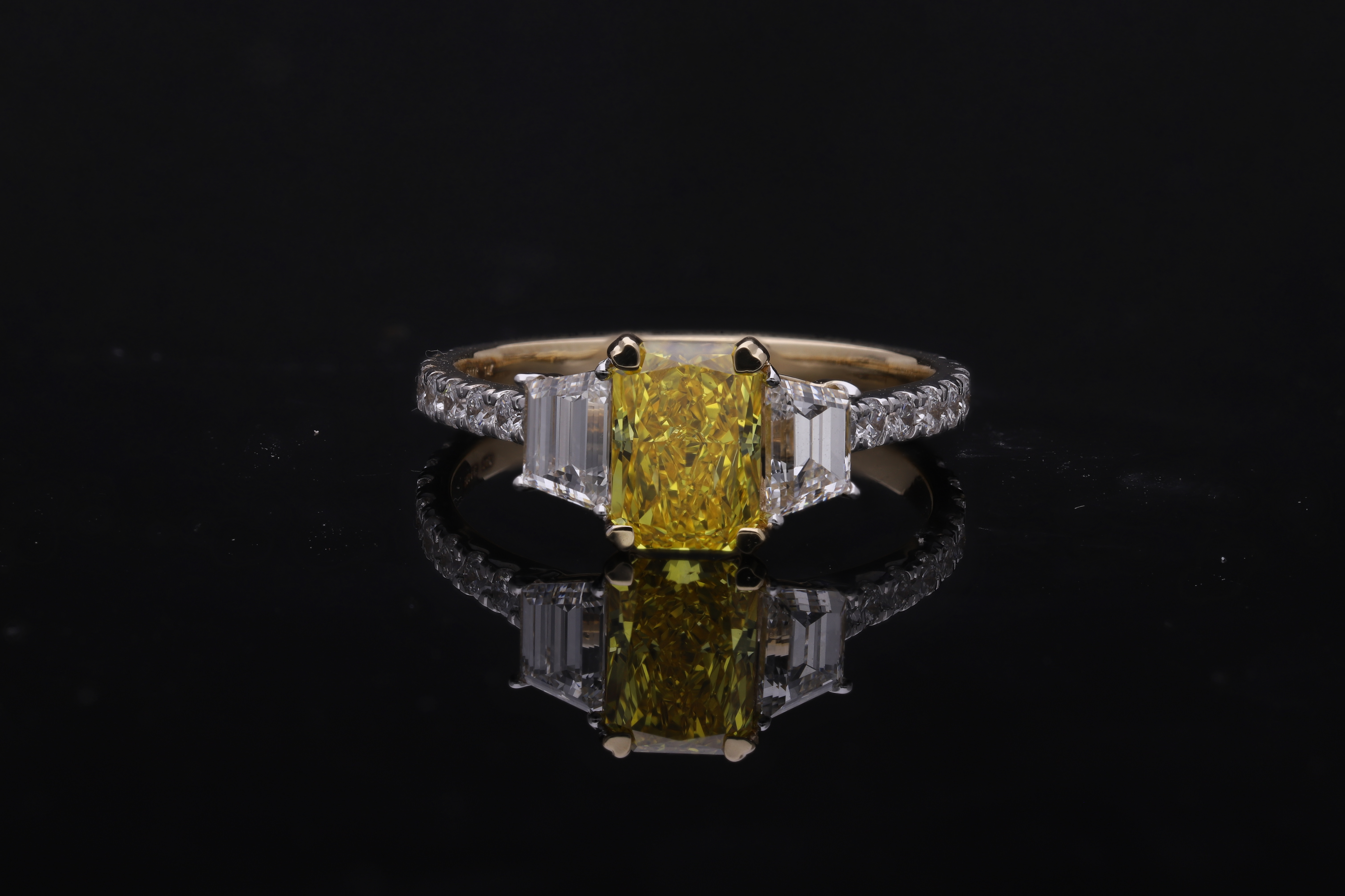 yellow color center radiant  with fancy trapezoid and round brilliant cut diamond engagement ring