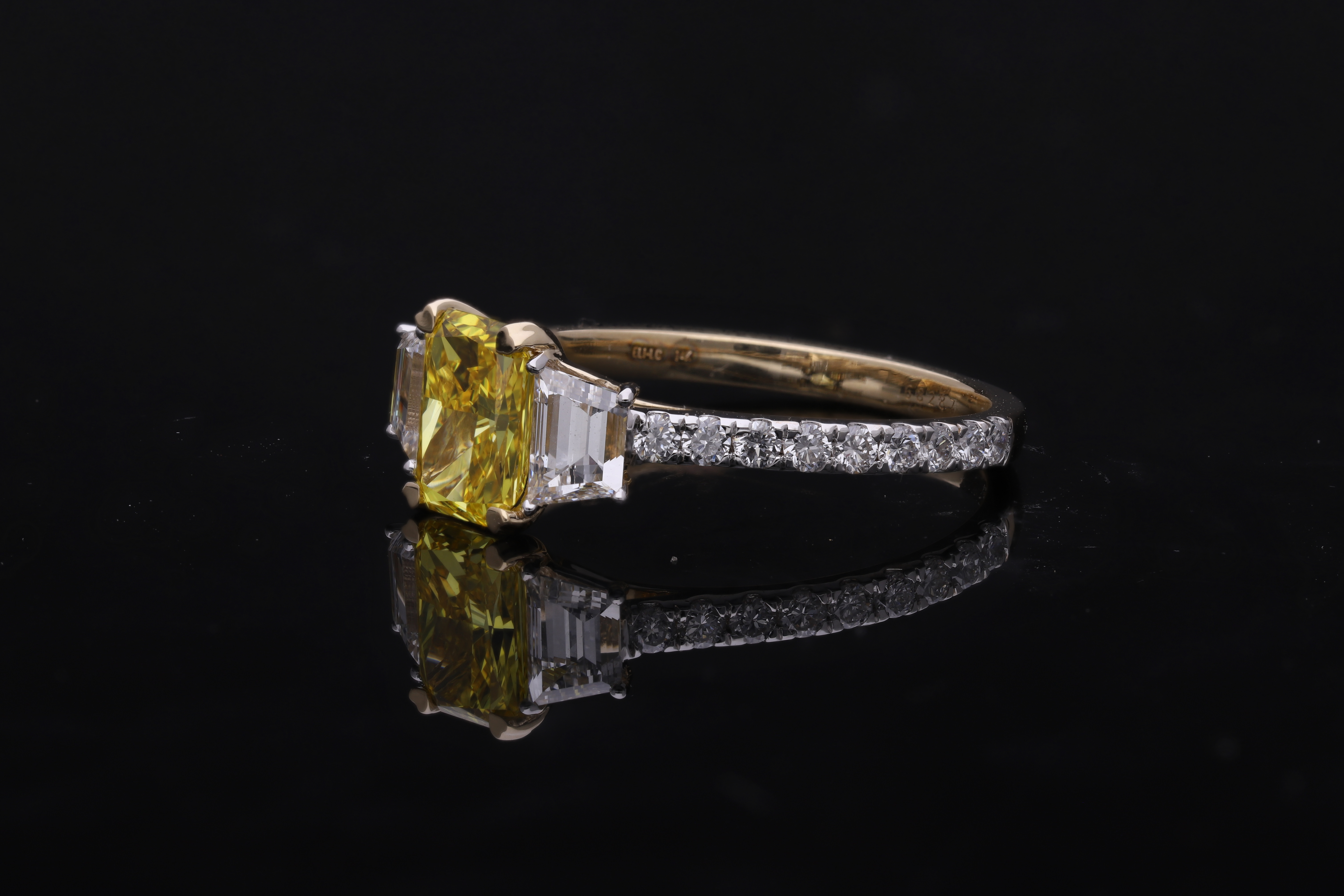 yellow color center radiant  with fancy trapezoid and round brilliant cut diamond engagement ring