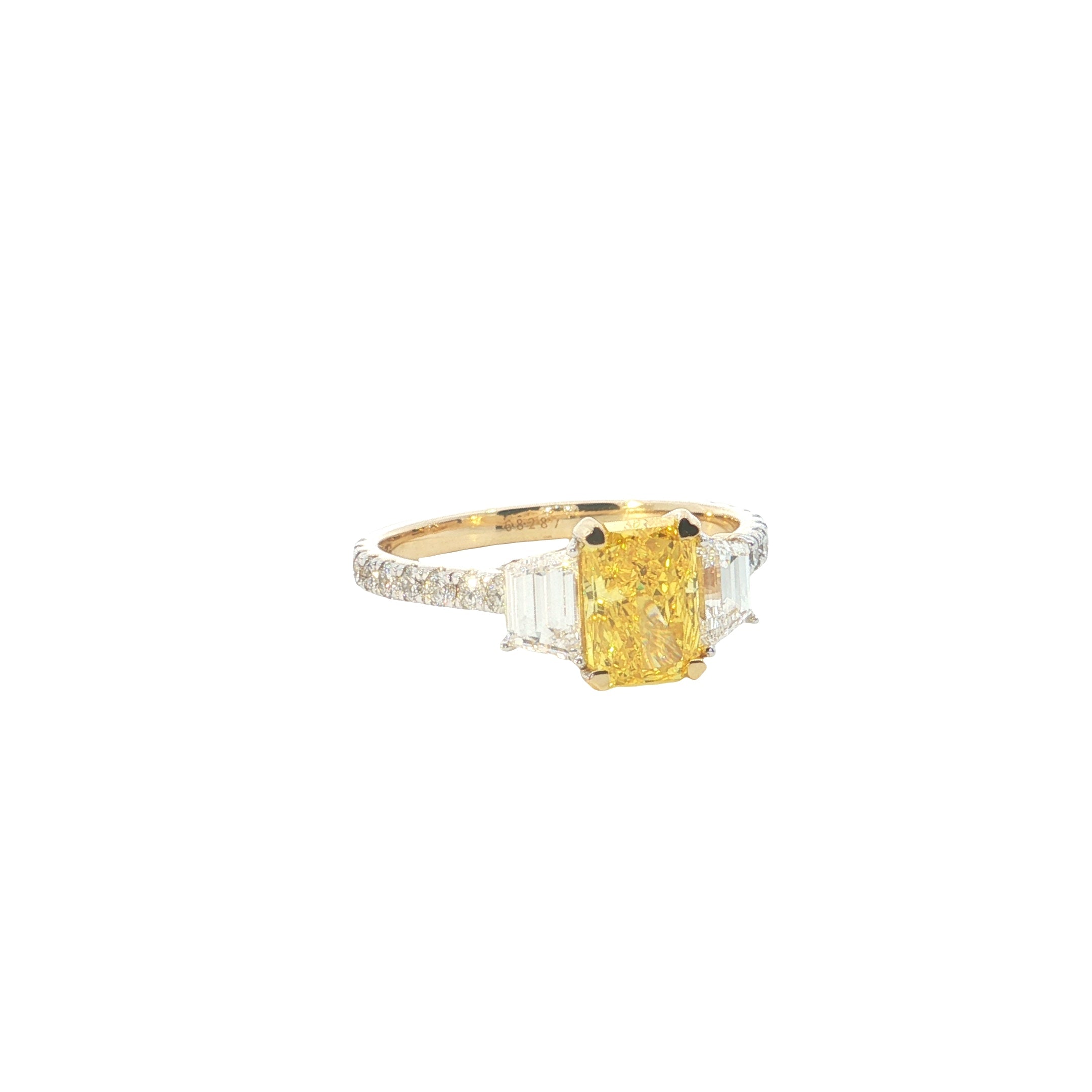 yellow color center radiant  with fancy trapezoid and round brilliant cut diamond engagement ring